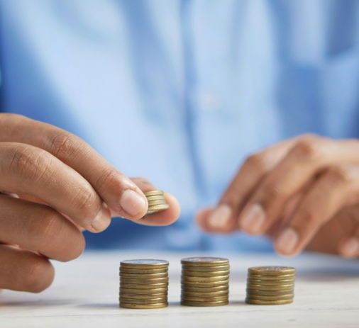 a-person-stacking-coins-on-top-of-a-table.jpg a person stacking coins on top of a table